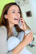 Woman talking on the phone and drinking coffee