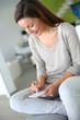 Woman at home relaxing and using smartphone