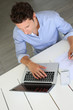 Upper view of smart guy working on laptop at home