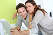 Cheerful couple websurfing on internet with tablet