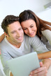 Photo: Cheerful couple websurfing on internet with tablet Cheerful couple websurfing on internet with tablet