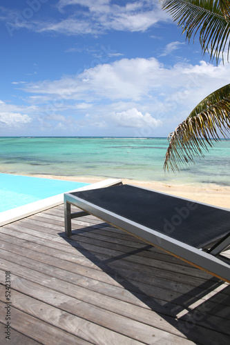 Photo: Infinity pool with deck chair by the beach Infinity pool with deck chair by the beach
