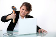 Woman smashing laptop with hammer