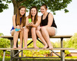 pre-teen girls texting while hanging out at their school