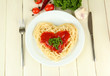 Cooked spaghetti carefully arranged in  heart shape and topped