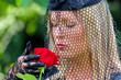 Witwe mit Schleier und Rose