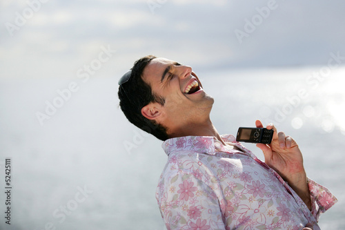 Photo: Man laughing by the water's edge Man laughing by the water's edge