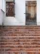 old traditional porch with brick stairs and locked wooden door