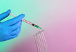 Hands in gloves and test tubes on blue-purple background