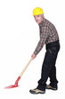 Mature construction worker working with a shovel.