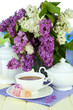 Composition with beautiful lilac flowers, tea service