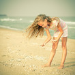 Photo: girl on the beach collecting shells girl on the beach collecting shells