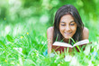 Photo: dark-haired young woman reading red book dark-haired young woman reading red book