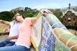 Couple of tourists relaxing on Guell Park bench