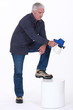 Photo: Mature man using paint sprayer Mature man using paint sprayer