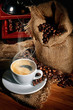 Photo: Coffee grinder and cup of coffee on brown wooden background Coffee grinder and cup of coffee on brown wooden background