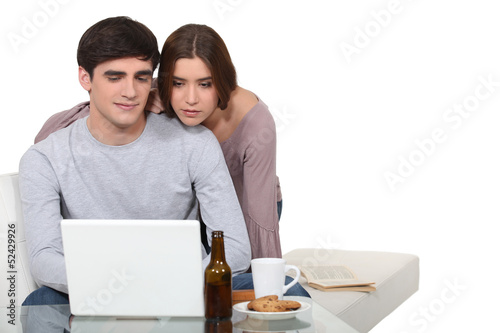 Photo: Couple looking at a laptop Couple looking at a laptop