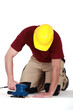 Builder using sander on floor