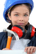 Child with a hammer, hardhat and ear defenders