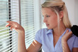 woman watching through blinds