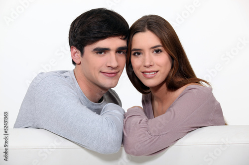 Photo: Couple sitting on their couch Couple sitting on their couch