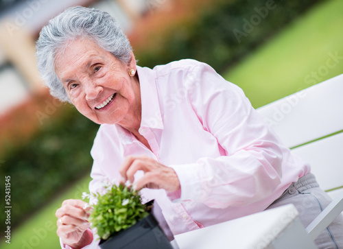 Photo: Retired woman fixing a plant Retired woman fixing a plant