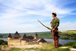 Medieval archer with bow and arrows on castle background