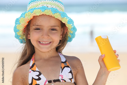 Photo: little girl on the beach with a sun cream little girl on the beach with a sun cream