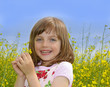 happy little girl with rapeseed (colza) flower