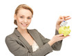 woman putting cash money into small piggy bank
