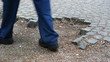People walking on damaged pavement