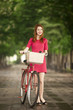 Redhead girl with bike at outdoor, city.