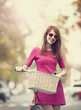 Redhead girl with bike at outdoor, city.