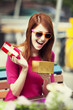 Style redhead girl with gift sitting on the bench in the cafe