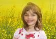 little girl on a field with colza