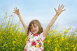 happy little girl on a field with flowering colza