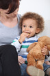 Photo: Mother sat with toddler eating biscuits Mother sat with toddler eating biscuits