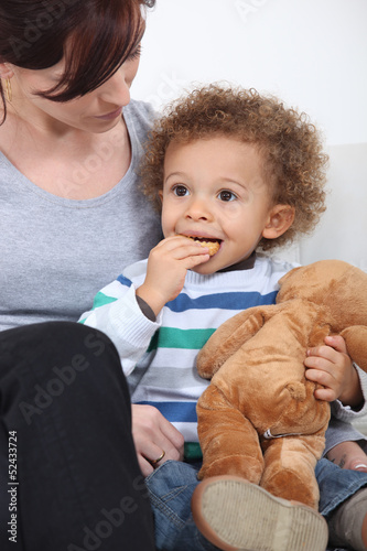 Photo: Mother sat with toddler eating biscuits Mother sat with toddler eating biscuits