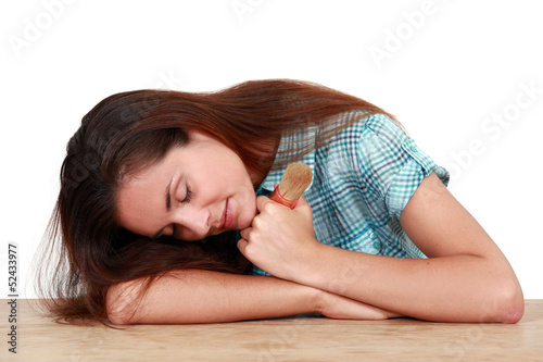 Photo: woman sleeping on a table and holding a paint brush woman sleeping on a table and holding a paint brush