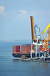 Photo: Container stack and ship under crane bridge Container stack and ship under crane bridge