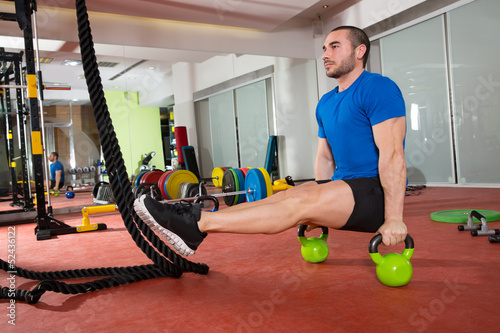 Photo: Crossfit fitness man L-sits Kettlebells L sits exercise Crossfit fitness man L-sits Kettlebells L sits exercise