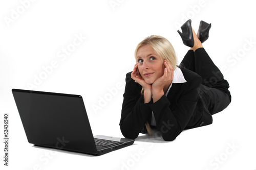Photo: Woman daydreaming in front of her laptop Woman daydreaming in front of her laptop
