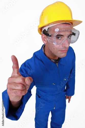 Photo: Manual worker with a finger up. Manual worker with a finger up.