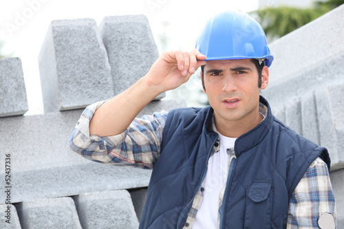 Photo: Construction worker in a hardhat next to concrete kerbing Construction worker in a hardhat next to concrete kerbing