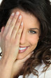 Foto: Woman covering an eye with her hand Woman covering an eye with her hand