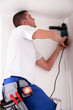Man drilling hole in ceiling