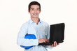 An architect standing while typing on his laptop.