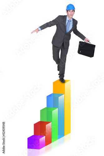 Photo: Businessman balancing on bar chart Businessman balancing on bar chart