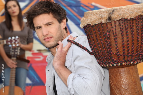 Photo: Young man carrying a djembe Young man carrying a djembe