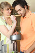 Photo: young woman and companion tasting dish young woman and companion tasting dish